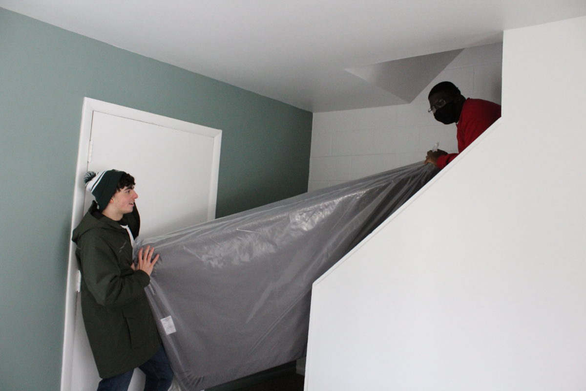 EMU students carrying a mattress down the stairs