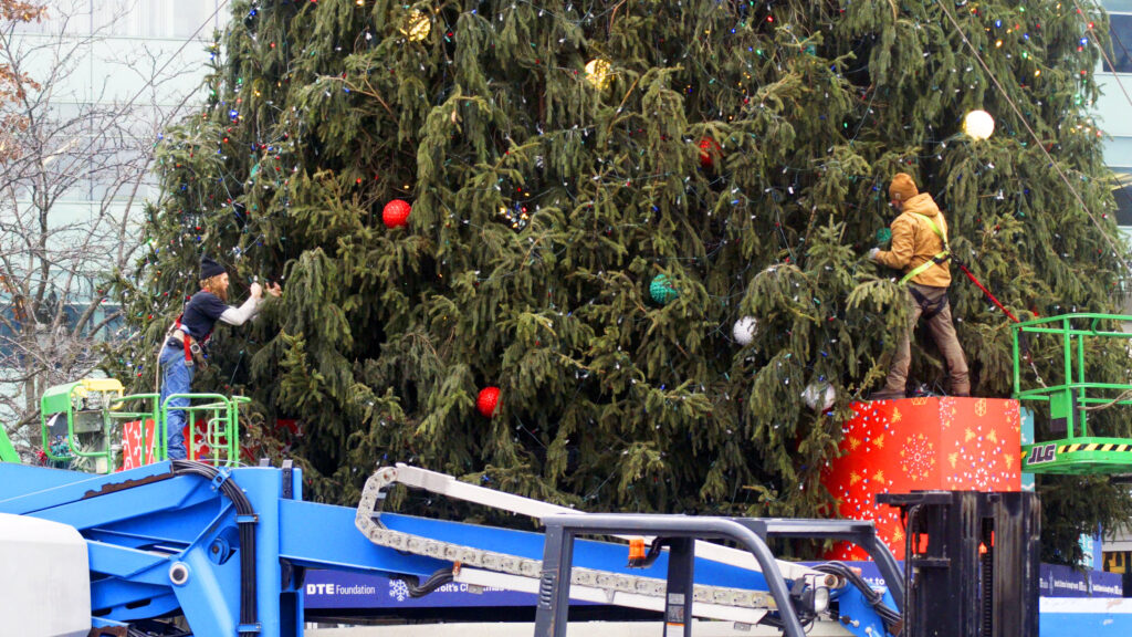 Volunteers decorate the massive Christmas tree at Campus Martius Mark